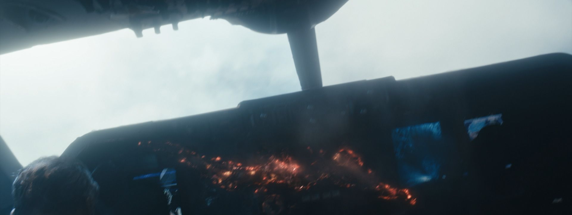 An airliner cockpit with burning, melted controls and cloud beyond the windscreen, from The Boys.