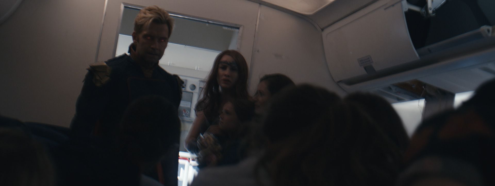 Homelander and Queen Maeve among frightened passengers in the airliner cabin, from The Boys.