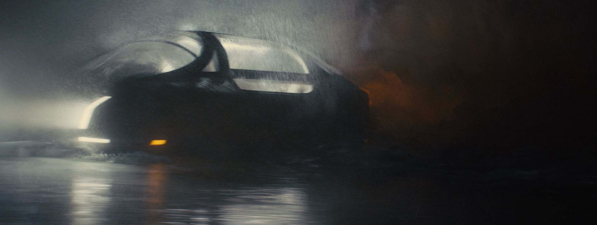 A spinner flies low over black water through fog and rain, from Blade Runner 2049.
