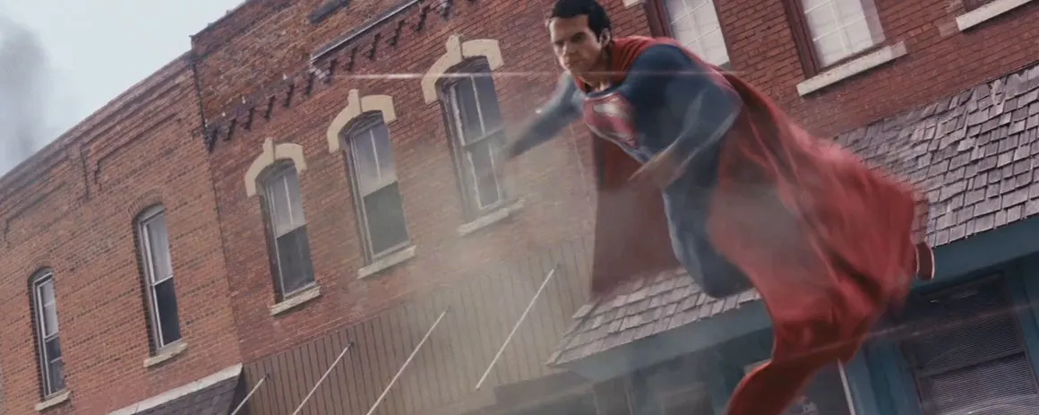 Final shot: Superman flies past brick storefronts through smoke.