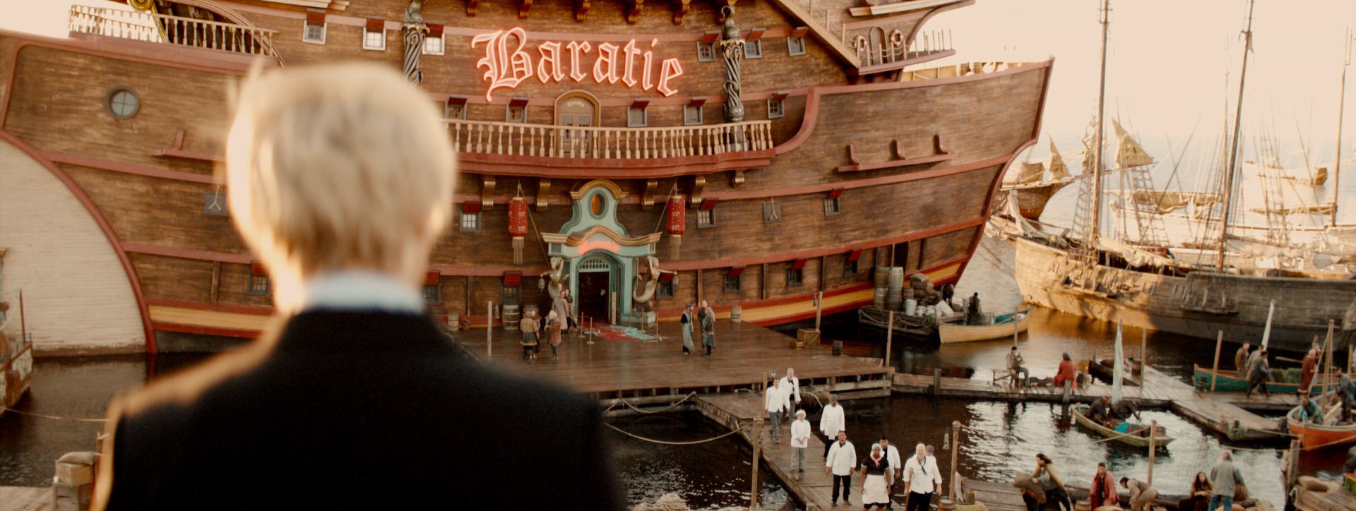 Sanji looks out at the Baratie, a ship-shaped floating restaurant in a busy harbour, from One Piece.